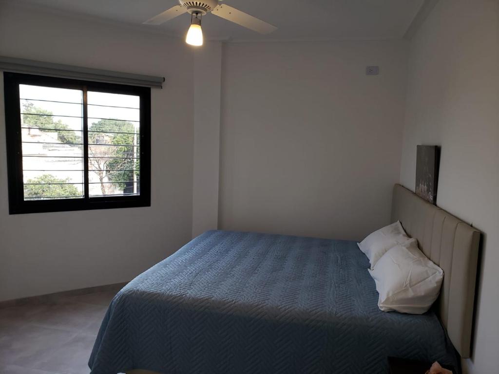 Ganesha Abasto Apartments في سان ميغيل دي توكومان: غرفة نوم بسرير ونافذة