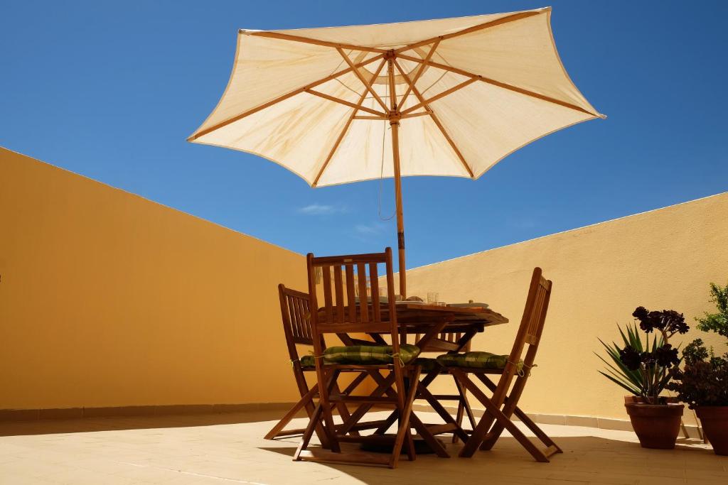 a table and two chairs with an umbrella at Few Steps to the Beach in Alvor
