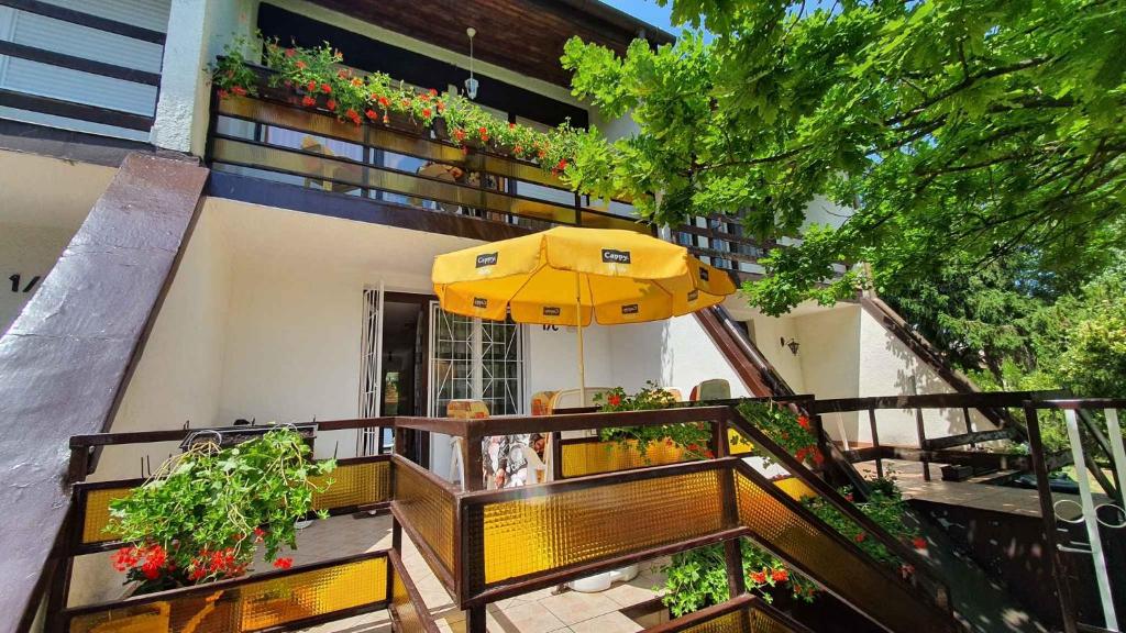シオーフォクにあるHoliday home in Siofok/Balaton 19924のパティオ(黄色の傘、テーブル付)