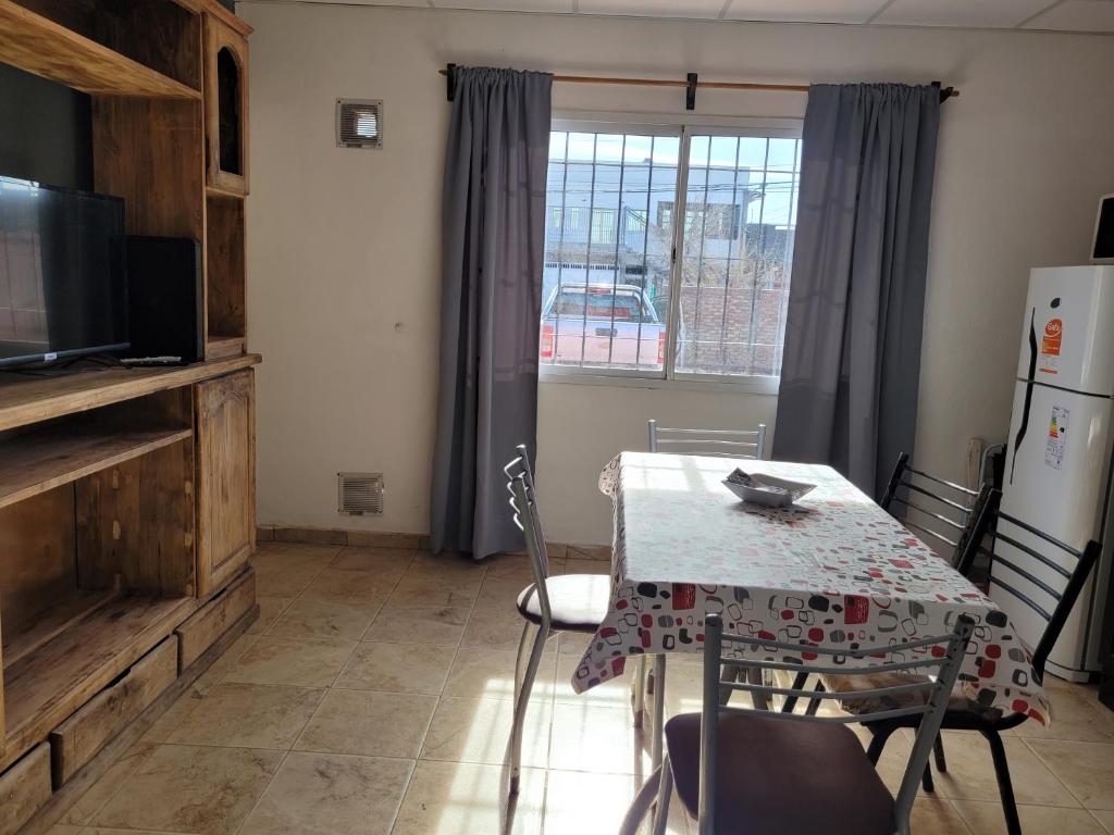 a kitchen with a table and a refrigerator and a window at Rosetta in Malargüe