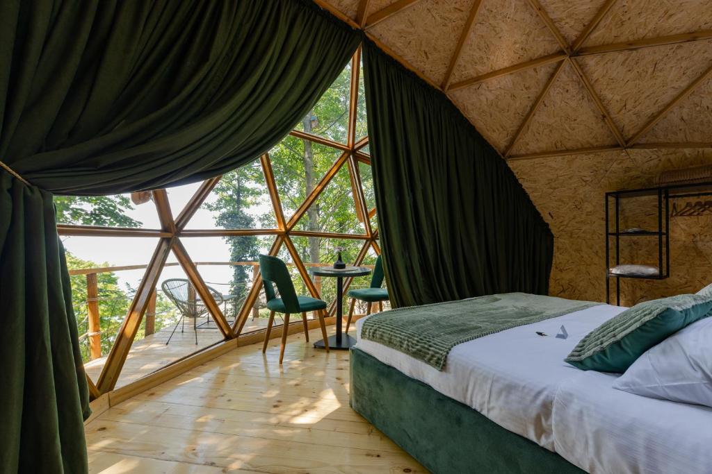 a room with a bed and a large window at Glamping Martini Kvariati in Batumi