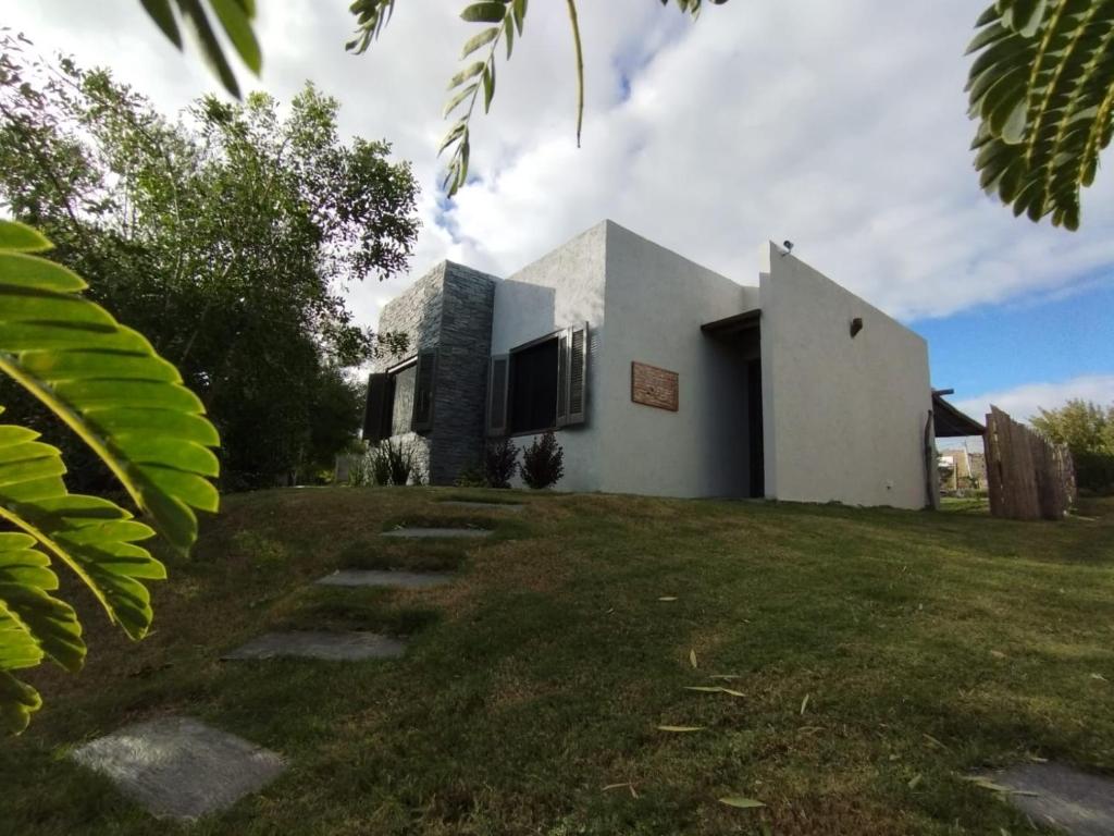 una casa en un campo de hierba con un edificio en Churrinche en Cuchilla Alta