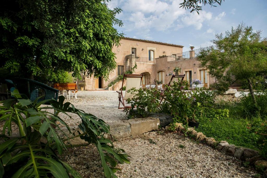 an old house with a garden in front of it at Farm stay La Frescura Agriturismo in Siracusa