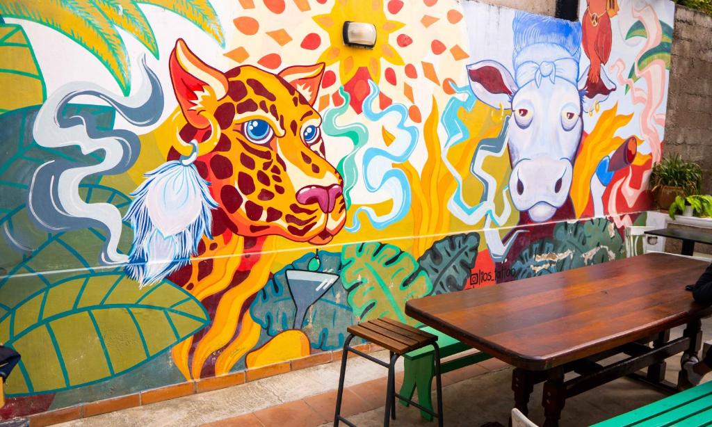 a wall with a mural of a giraffe and a cow at Trotamundos hostel Salta in Salta