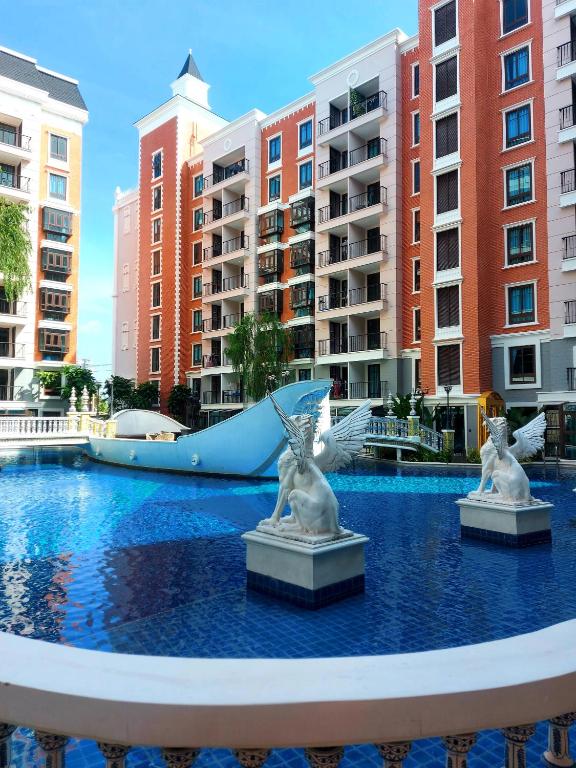 two white statues in the middle of a pool with a slide at Espana Resort Pattaya Jomtien in Jomtien Beach