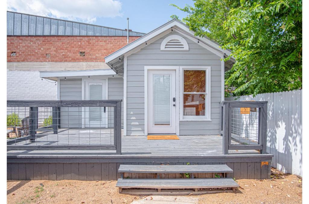 a gray house with a porch and a fence at Adorable Guesthouse So Close to Amazing Downtown in San Antonio