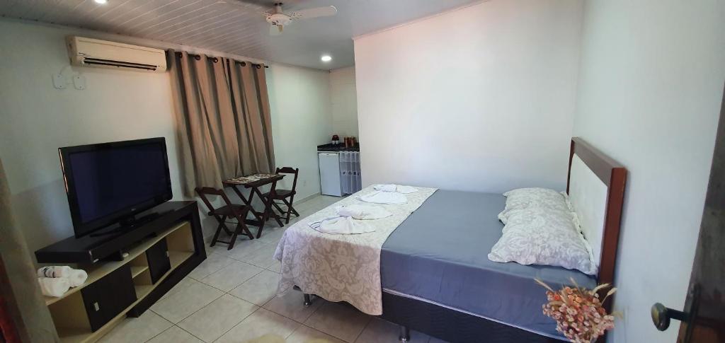 1 dormitorio con 1 cama, TV y mesa en ROUTE 333, en Miguel Pereira