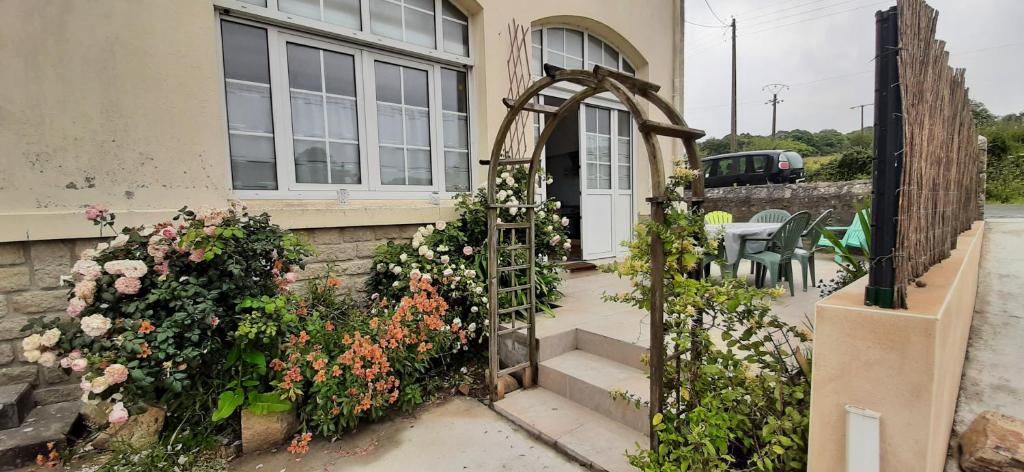 une maison avec une porte et des fleurs devant elle dans l'établissement 12 RDC Appartement 2 chambres jardin terrasse, à Plonéour-Lanvern