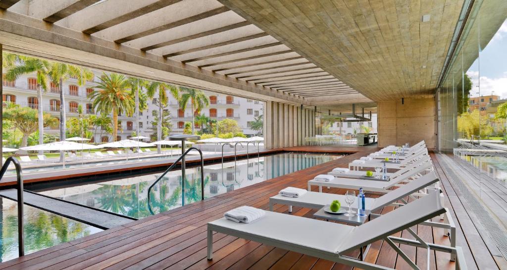 a hotel with a pool and tables and a swimming pool at Iberostar Heritage Grand Mencey in Santa Cruz de Tenerife