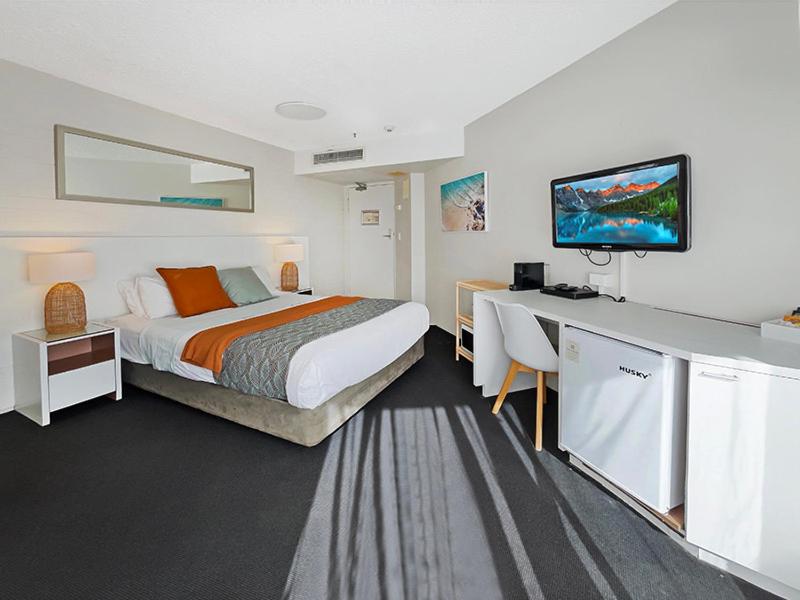um quarto de hotel com uma cama e uma secretária com uma televisão em Seaside Stays Marcoola Private studio 2515 em Marcoola