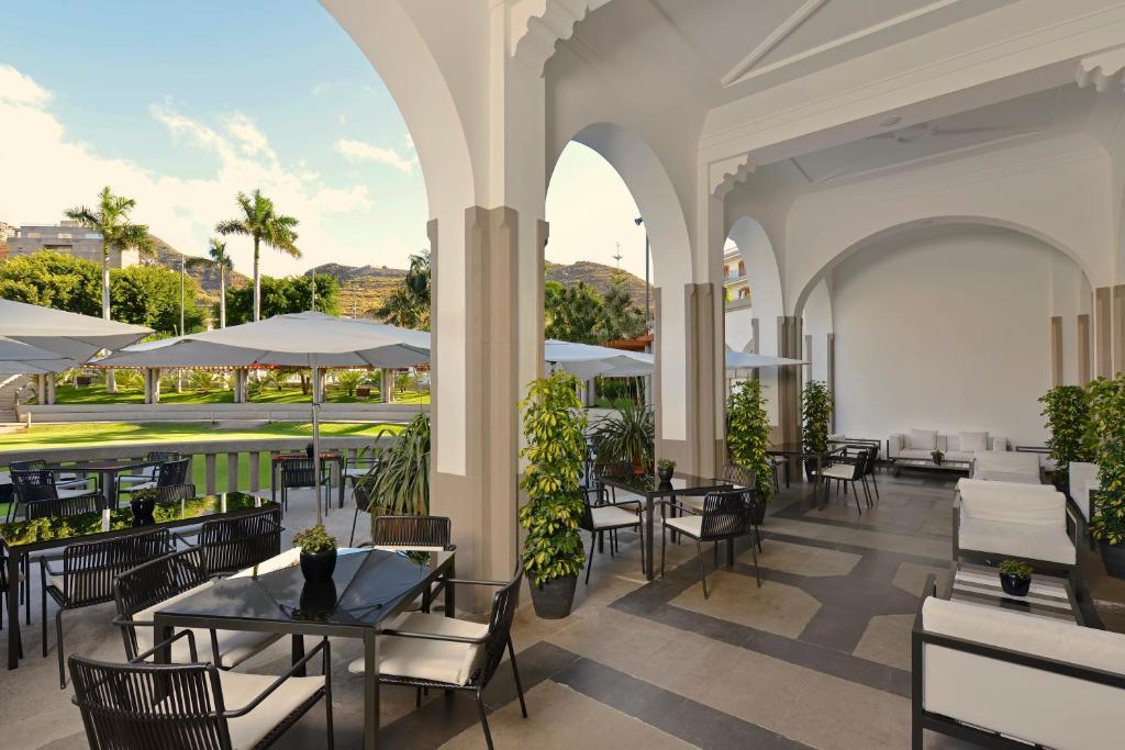 an outdoor patio of a restaurant with tables and chairs at Iberostar Heritage Grand Mencey in Santa Cruz de Tenerife