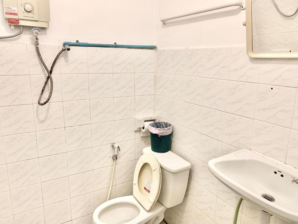 a white bathroom with a toilet and a sink at Beck's Resort in Haad Pleayleam