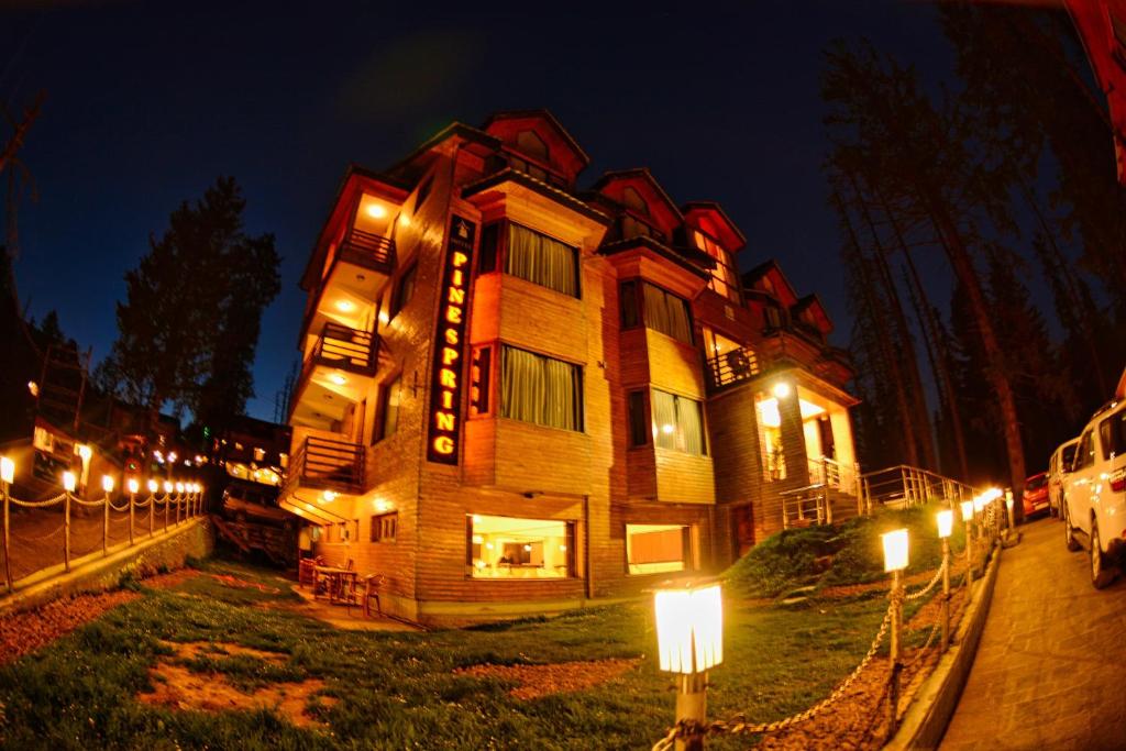 ein Gebäude mit Lichtern in der Nacht davor in der Unterkunft Hotel Pine Spring Gulmarg in Gulmarg