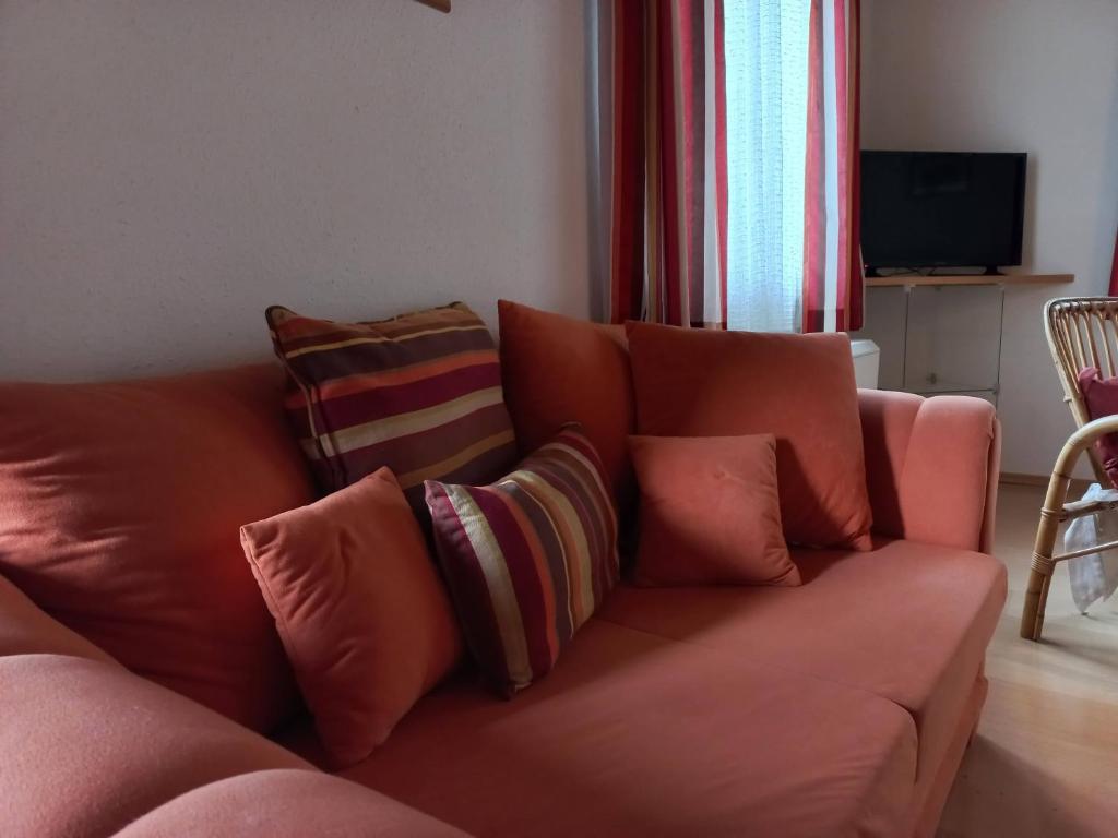 a couch with pillows on it in a living room at Appartements direkt am See in Grundlsee