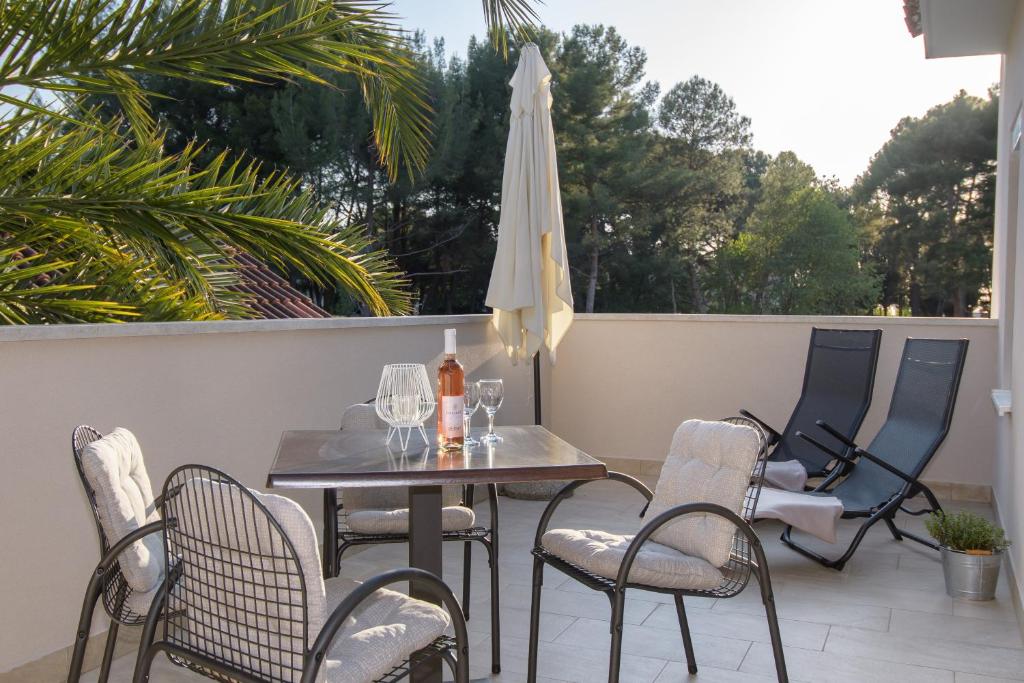 a patio with a table and chairs and an umbrella at Apartments & Rooms Darrer in Poreč