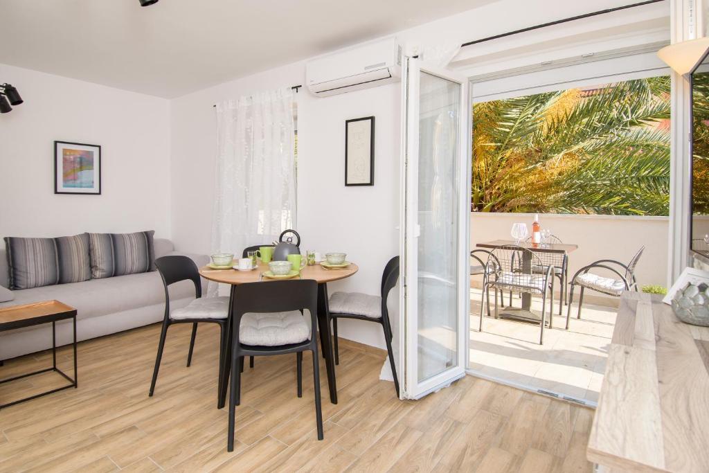 a living room with a table and chairs and a couch at Apartments & Rooms Darrer in Poreč