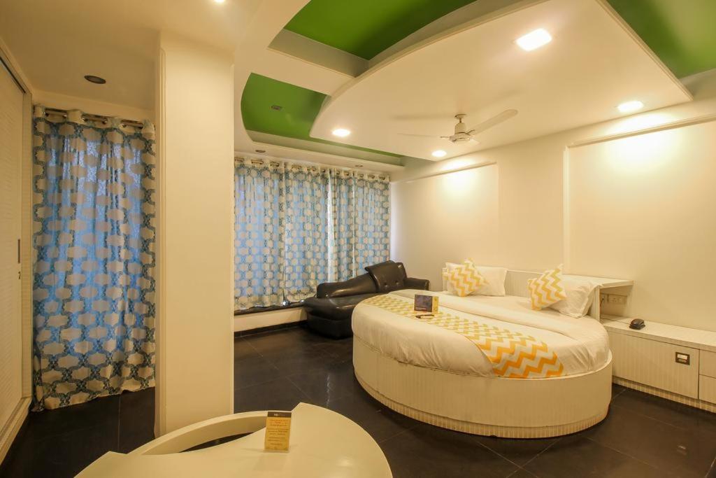 ムンバイにあるPANCHVATI RESIDENCY ANDHERI WESTのベッドルーム1室(大型ベッド1台、ソファ1台付)、