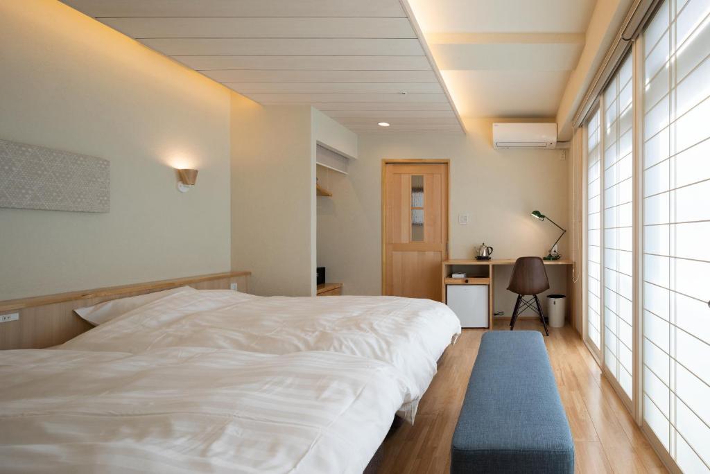 a bedroom with a white bed and a blue rug at Arima Koyado Uraku in Kobe