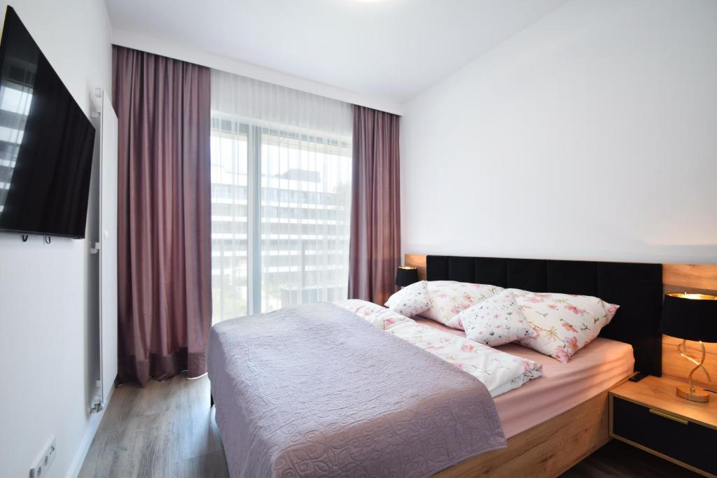 a bedroom with a bed and a large window at Apartament Rogowo 117L in Rogowo