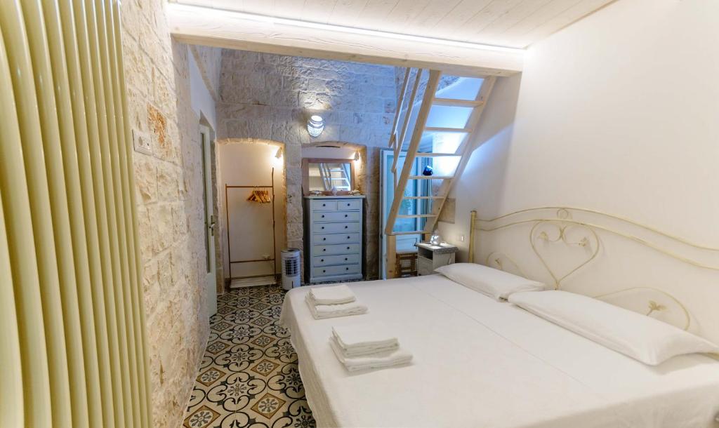 una camera con un letto bianco e una finestra di Casa Maristella a Cisternino