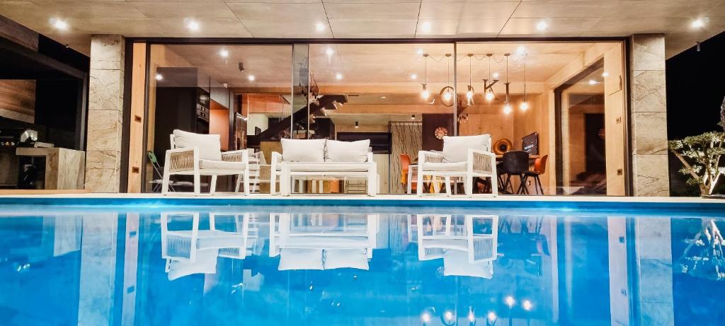 a house with a swimming pool and white chairs at Villa LorKia in Baška
