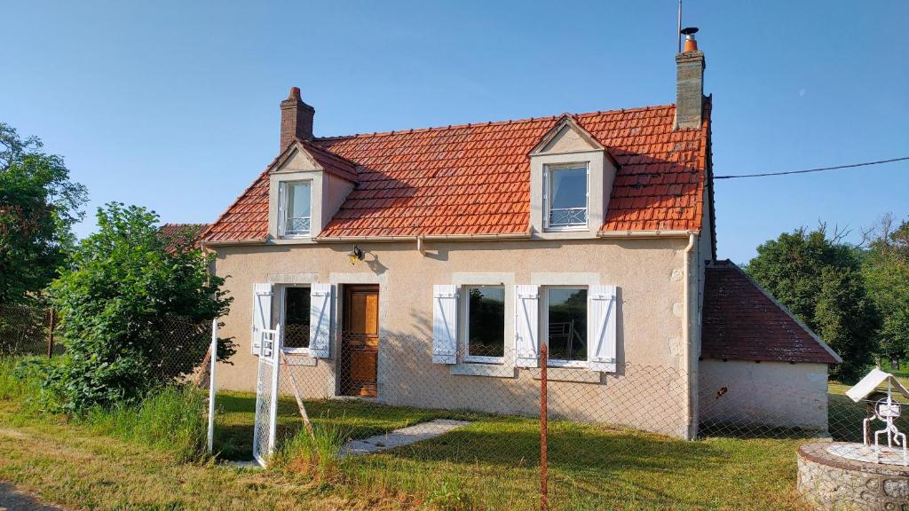 una pequeña casa blanca con techo naranja en Le Champ des Fougères, en Vicq-Exemplet