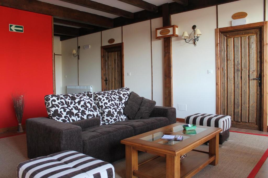 a living room with a couch and a coffee table at Hotel Rural Restaurante Las Baronas in Santa Cruz de la Salceda