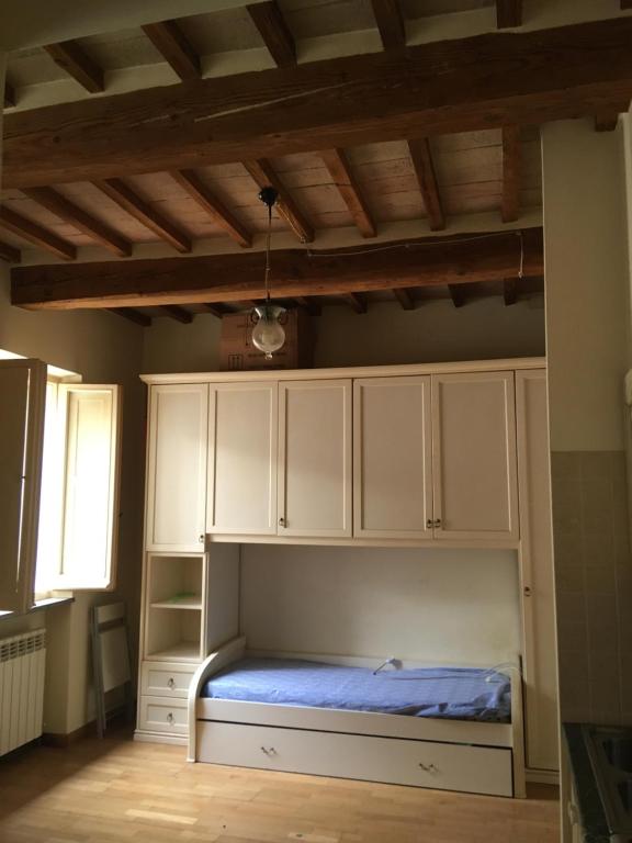 a bed in a room with white cabinets and a window at I 3 FRATELLI in Foligno