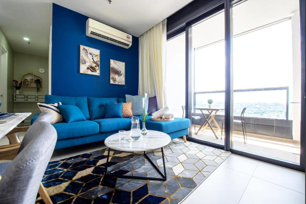 un salon bleu avec un canapé bleu et une table dans l'établissement Arcoris Mont Kiara next 163plaza 1-4Pax one plus one Bedroom, à Kuala Lumpur