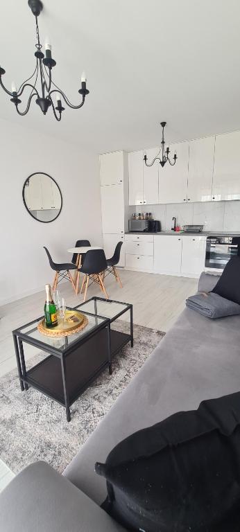 ein Wohnzimmer mit einem Couchtisch und einer Küche in der Unterkunft 20 - Apartamenty Siedlce - Nowy apartament przy ul Lewandowskiego in Siedlce
