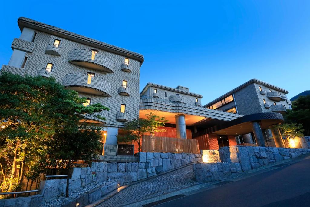 a building with a stone wall next to a street at Merveille Hakone Gora in Hakone