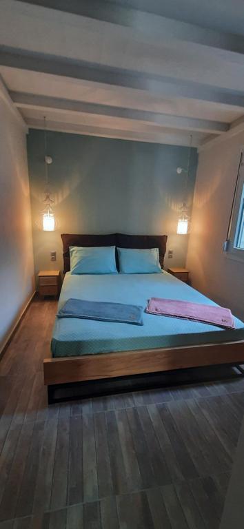 1 dormitorio con 1 cama grande con sábanas y almohadas azules en Central apartment, en Patitiri