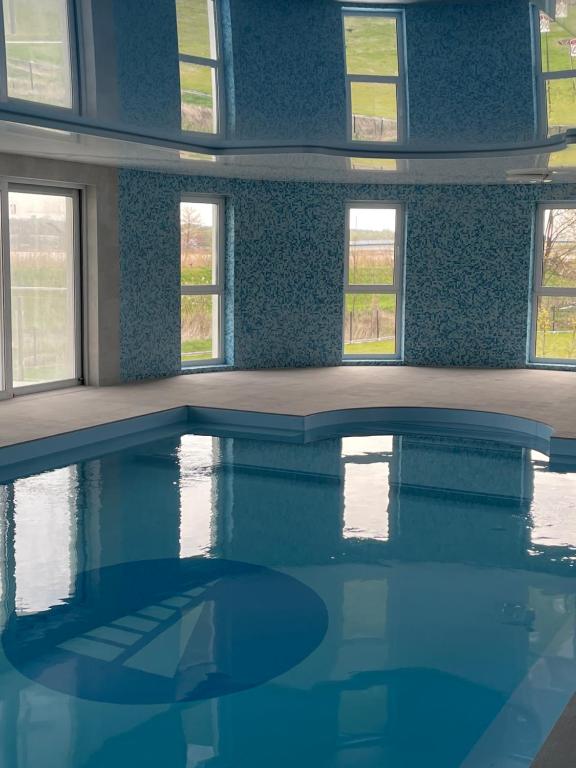 uma sala vazia com uma piscina com janelas em Apartamenty Pod Żaglami em Zegrze