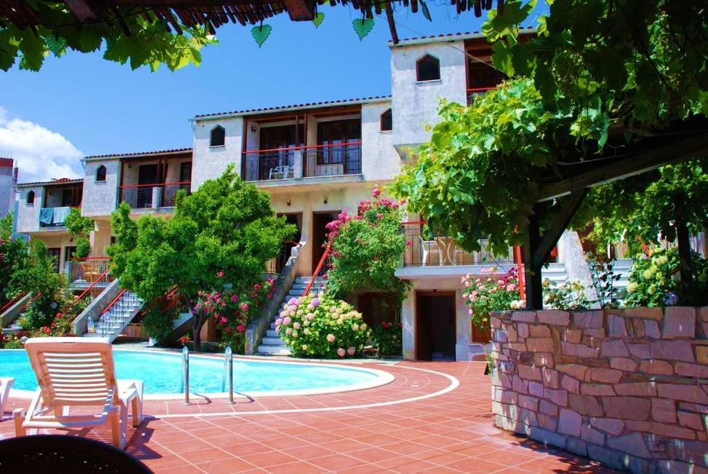 a building with a swimming pool in front of a building at Kipos Hotel in Limenas