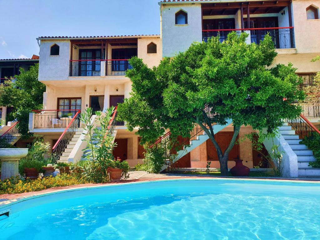 eine Villa mit Swimmingpool vor einem Haus in der Unterkunft Kipos Hotel in Limenas