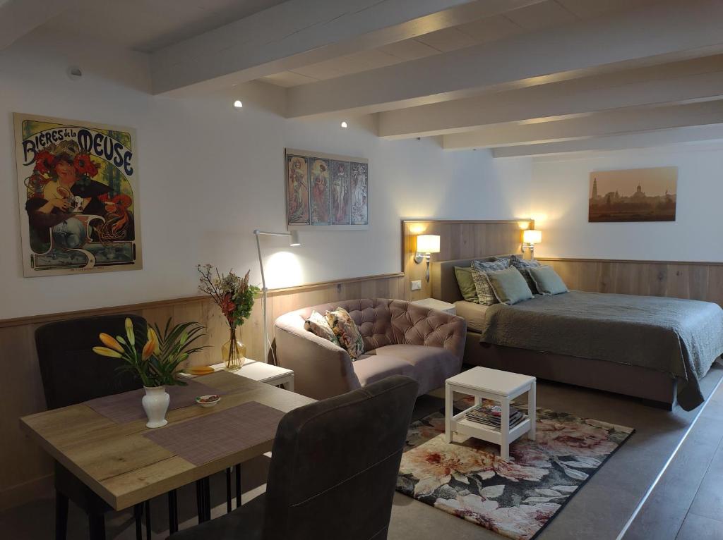 1 dormitorio con cama, sofá y mesa en VRYE HEERLYKHEYD ( adults only ) studio 2 en Middelburg