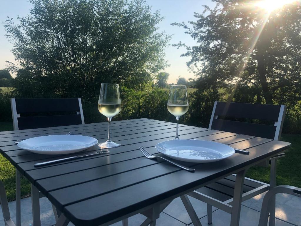 einen Holztisch mit zwei Gläsern Weißwein in der Unterkunft 2 Gastenverblijven in het Groene Hart nabij Utrecht 