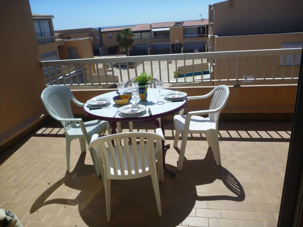 une table et des chaises assises sur un balcon dans l'établissement Appartement 4 pers avec vue mer proche plage, animaux et parking inclus - FR-1-387-85, à Marseillan