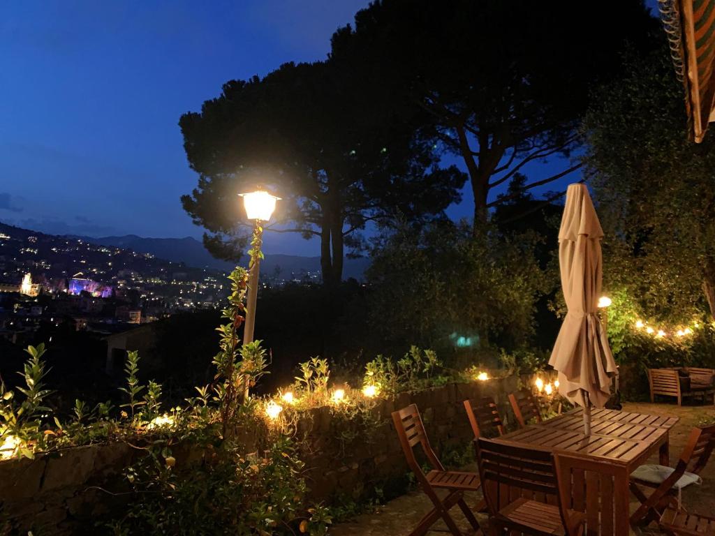 uma mesa com um guarda-chuva e uma luz de rua à noite em B&B Monte di Portofino em Santa Margherita Ligure