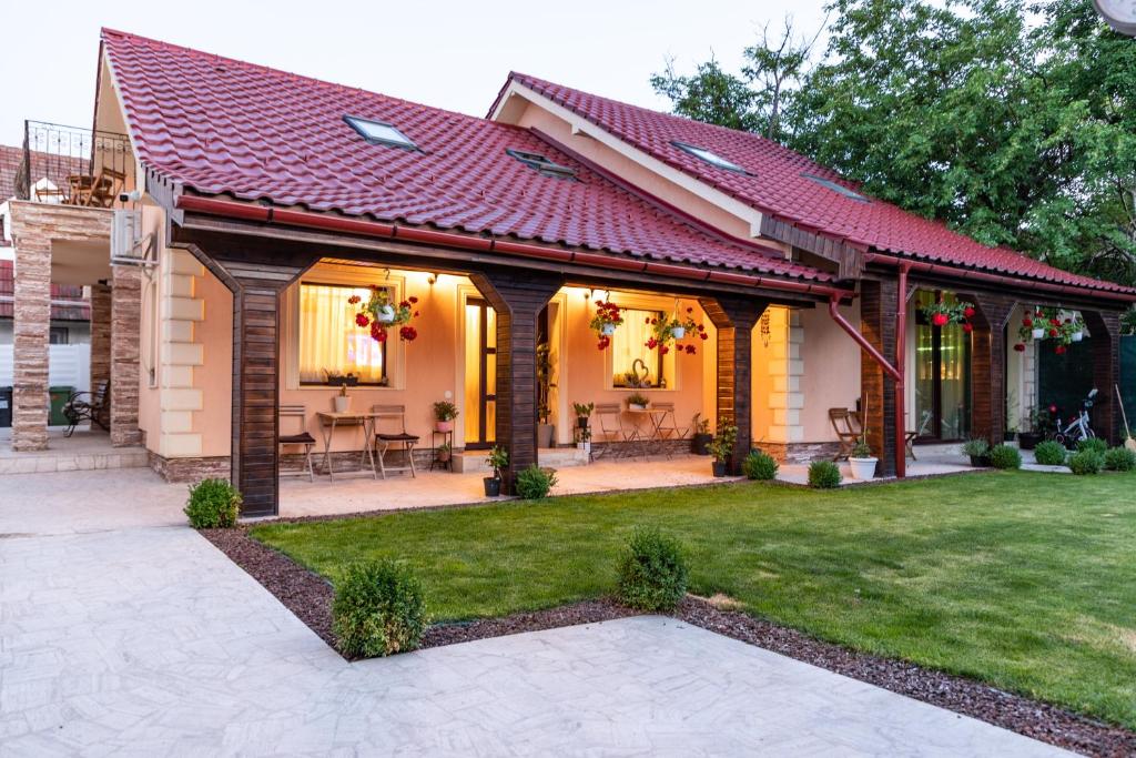 una casa con techo rojo y patio en Villa DEA DORATA en Oradea
