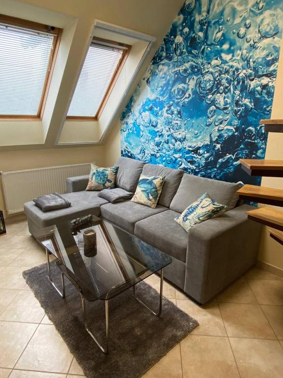 salon z kanapą i obrazem w obiekcie Buborék Apartman w Hajduszoboszlo