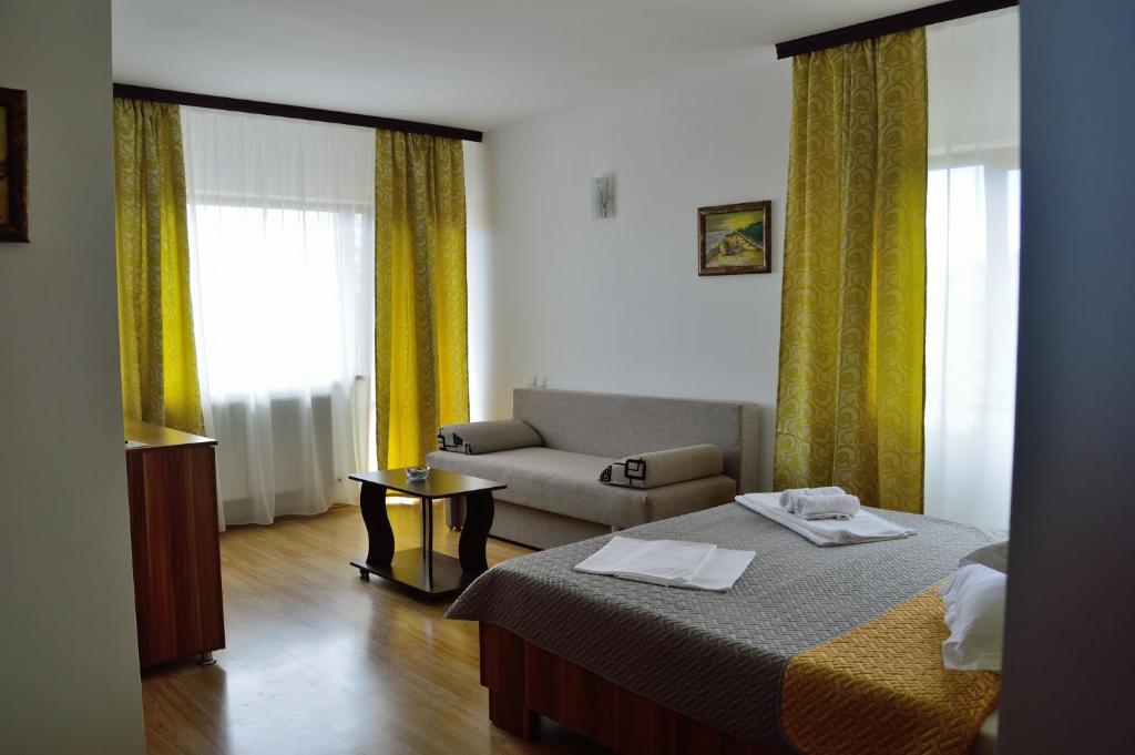 a hotel room with a bed and a couch at Helen Rooms Vama Veche in Vama Veche