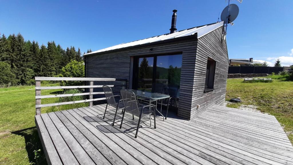 une petite cabine avec une table et des chaises sur une terrasse dans l'établissement Chata Luční, à Klíny