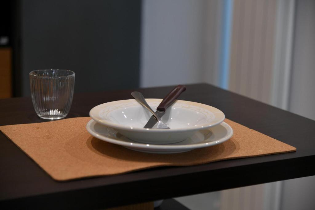 talerz z łyżką i widelcem na stole ze szkłem w obiekcie CASA ARIANNA w mieście Ischia