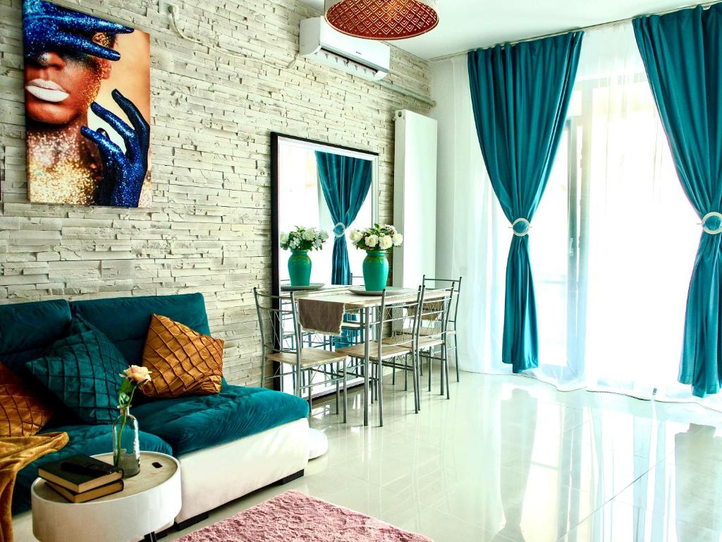 a living room with a couch and a table with chairs at Style apartment in Mamaia Nord