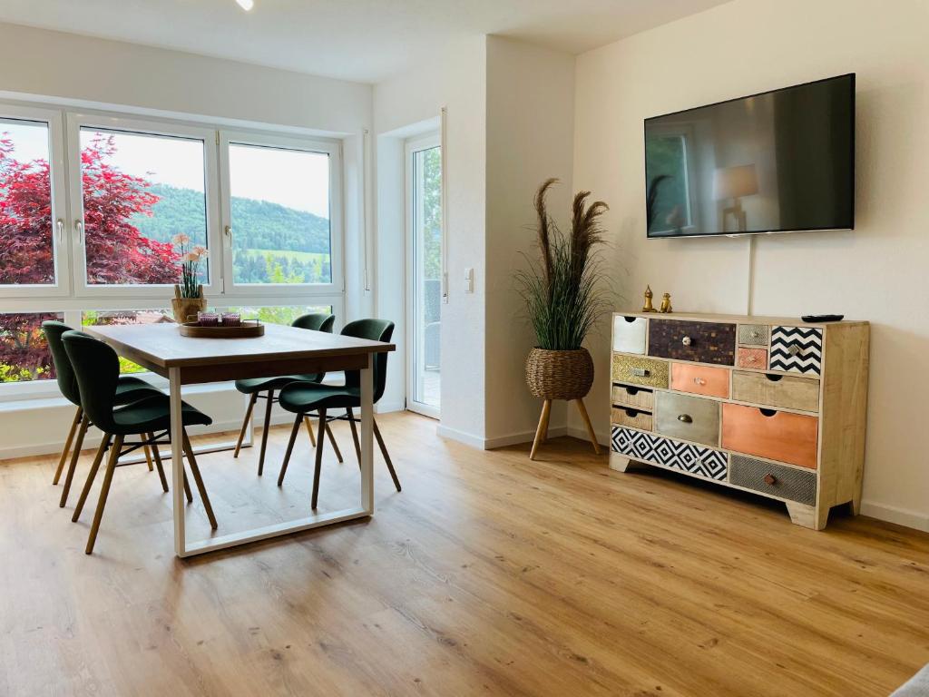 uma sala de jantar com mesa e cadeiras e uma televisão em Zollernalb-Apartment em Albstadt