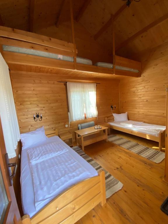 a large room with a bed and a window at Gyopar Wooden Houses in Izvoare