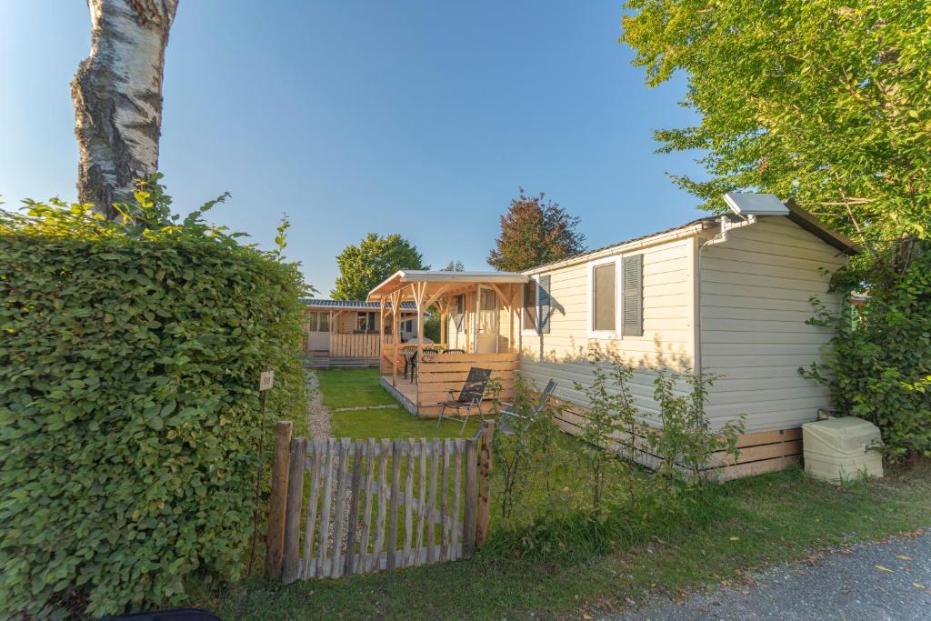 a house with a fence next to a yard at Hoamat#am#See in Seekirchen am Wallersee