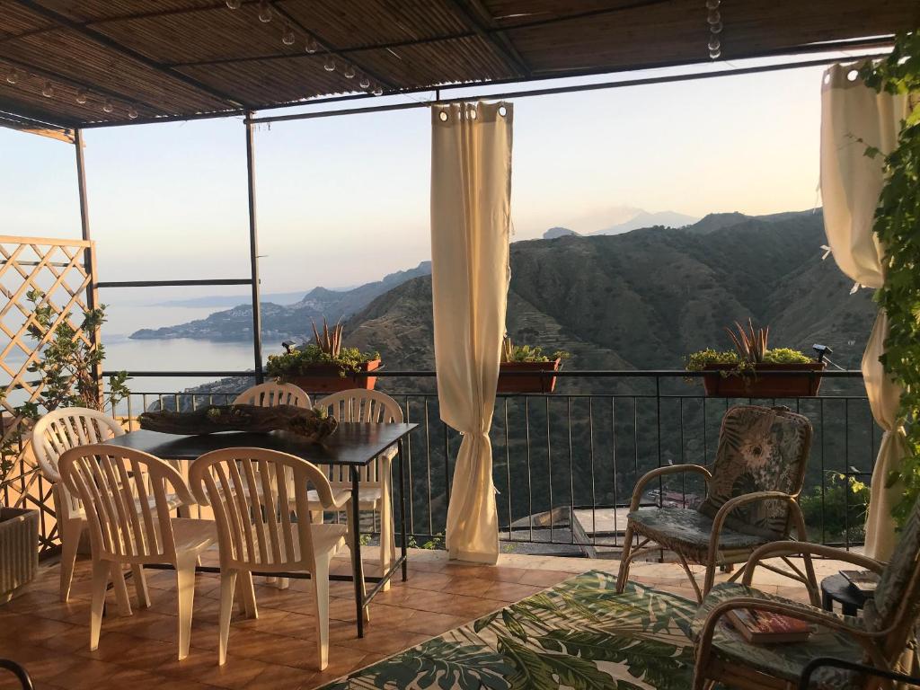 een tafel en stoelen op een balkon met uitzicht op de bergen bij THE SECRET GARDEN in Forza dʼAgro