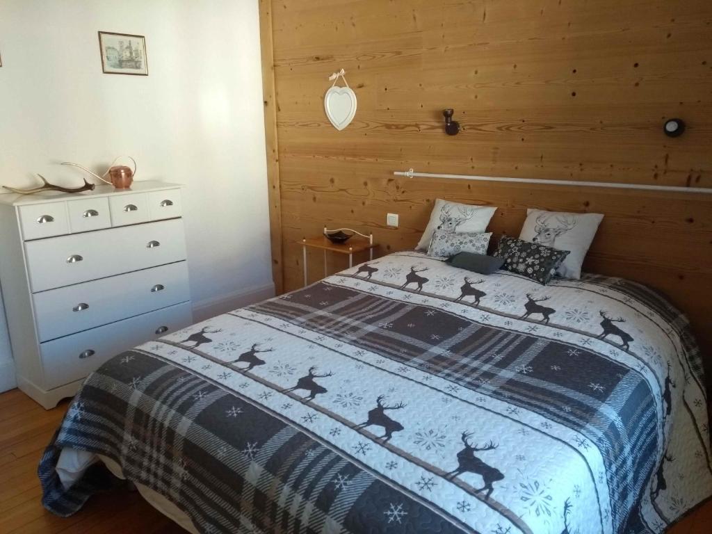 une chambre avec un lit et une commode dans l'établissement Cosy appartement La Bresse centre ville, à La Bresse